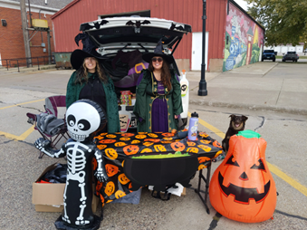 Two women in clothing standing in the trunk of a car

AI-generated content may be incorrect.